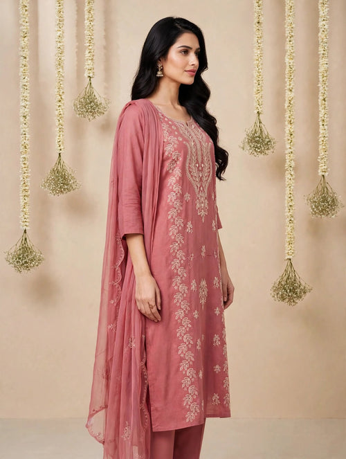 Woman wearing a dusty rose embroidered kurta set with dupatta