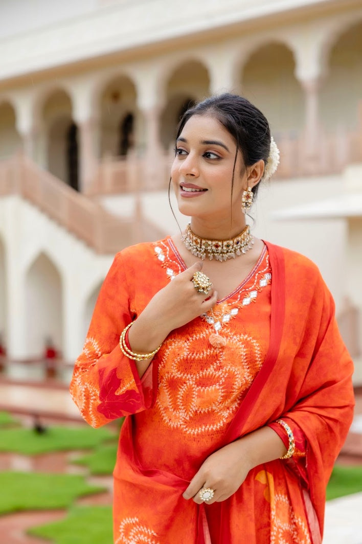 Front view of orange mirror-work kurta set with coordinated trousers